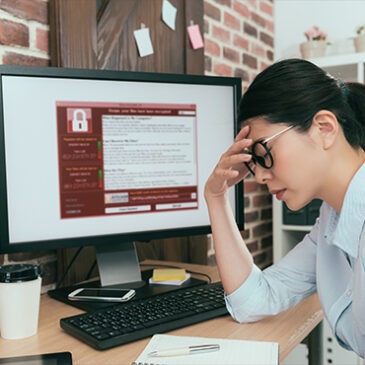 Stressed out woman in front of her computer. Image of a lock on her screen