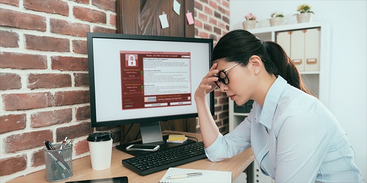 Stressed out woman in front of her computer. Image of a lock on her screen